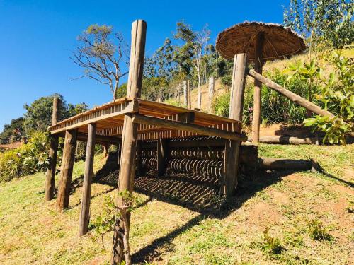 um banco de madeira sentado no topo de uma colina em Chalés Fenix em Santo Antônio do Pinhal