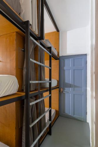 a room with bunk beds and a blue door at Akih Pods Hostel in Santa Teresa Beach