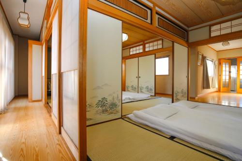 Oimazato大今里民泊 في أوساكا: غرفة نوم بسرير ومرآة كبيرة