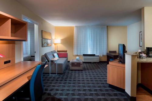 a hotel room with a couch and a television at TownePlace Suites by Marriott Atlanta Alpharetta in Alpharetta