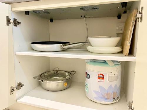 a shelf with bowls and plates and a pot at The Podium-Studio-Free 1 Parking-6 Pax-D321B in Kuching
