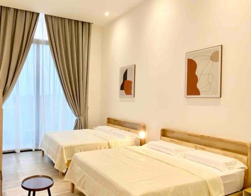 um quarto de hotel com duas camas e uma janela em The Podium@Studio ( 6 pax ) em Kuching