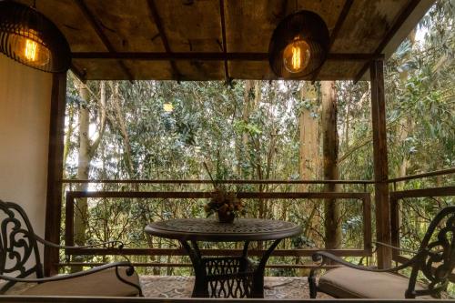 a table and chairs on a screened in porch at Hotel Boutique Guatika in Tibasosa