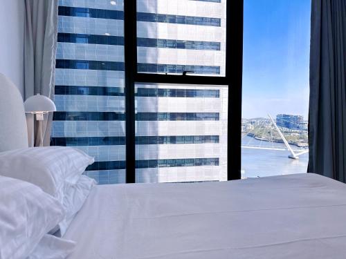 a bedroom with a large window with a view of a building at Centre of Brisbane at RiverFront in Brisbane