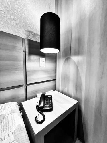 a telephone on a table next to a bed at Renoir - Av Barão Homem de Melo nº 4520 - pegar nº do flat no chat após reserva in Belo Horizonte