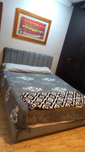 a bed in a room with a picture on the wall at Sweet home 1 in Mansoura