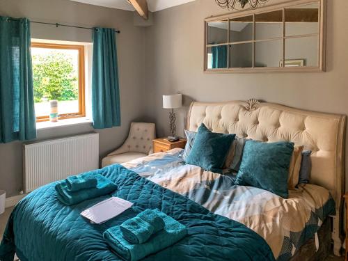 a bedroom with a large bed with blue pillows at Blue Mountain Barn in Scalby