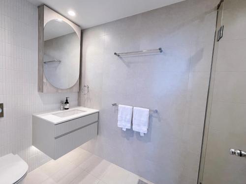a white bathroom with a sink and a shower at CBD Luxury River View 1Bed Apt The One in Brisbane