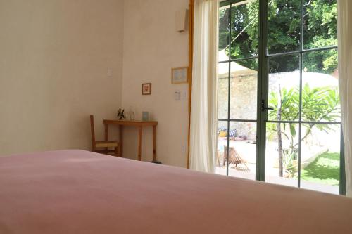 a bedroom with a bed and a large window at Nuik Casa Tropical in Mérida