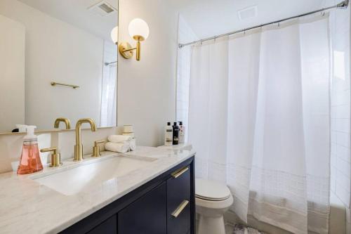 a bathroom with a sink and a toilet and a mirror at 5min-Grant park with Fenced Yard, Parking and Pet Friendly in Atlanta