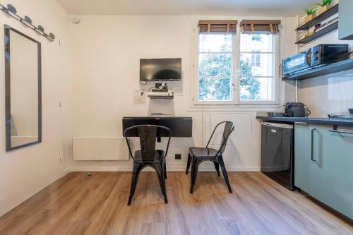- une cuisine avec une table et deux chaises dans une pièce dans l'établissement Peaceful studio - 2P - Faubourg-Montmartre, à Paris