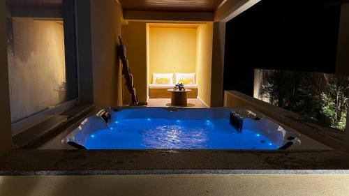 eine große blaue Badewanne im Bad mit Fenster in der Unterkunft Villa Gerês Emblematico - Piscina & Jacuzzi in Venda Nova