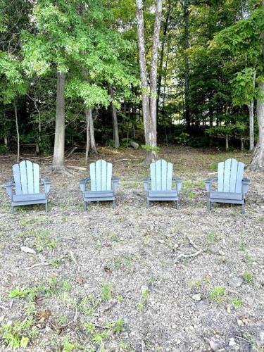 three blue chairs sitting in a field with trees at Lakeside Cabin - Serene Retreat with Lake Monroe Views and Wraparound Deck in Brown County in Nashville
