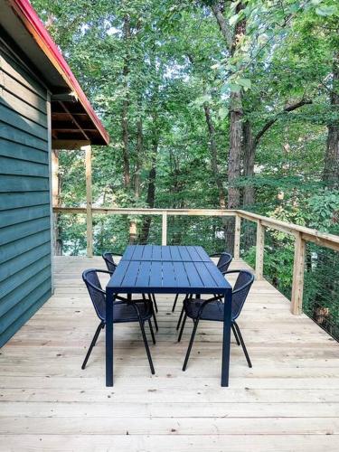 a blue table and chairs on a wooden deck at Lakeside Cabin - Serene Retreat with Lake Monroe Views and Wraparound Deck in Brown County in Nashville