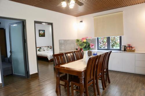 une salle à manger avec une table et des chaises ainsi qu'une cuisine dans l'établissement JE T'AIME VILLA - Khu nghỉ dưỡng nhà vườn nằm giữa thiên nhiên bao la hoa cỏ, à Bảo Lộc
