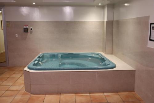 a jacuzzi tub in a bathroom with a tile floor at The Chancellor on Currie in Adelaide