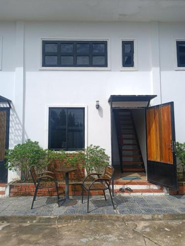 a patio with two chairs and a table and a building at Bella Vista Apartments in Kampot