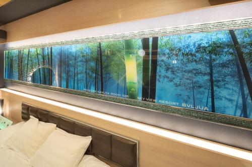 a large window with a view of a forest outside at ホテル ブルジュア 久留米 Hotel Bvljua -レジャーホテル- in Kurume