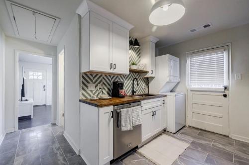 a kitchen with white cabinets and a tile floor at 5 min Grant park with Fenced Yard Parking Pet Friendly in Atlanta