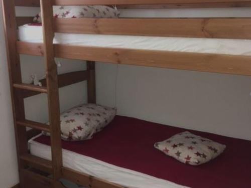 ein Etagenbett mit zwei Kissen im unteren Bett. in der Unterkunft Appartement 3P, 6 pers, proche pistes, balcon exposé Sud, parking privé, TV, cuisine équipée - FR-1-762-5 in Le Monêtier-les-Bains