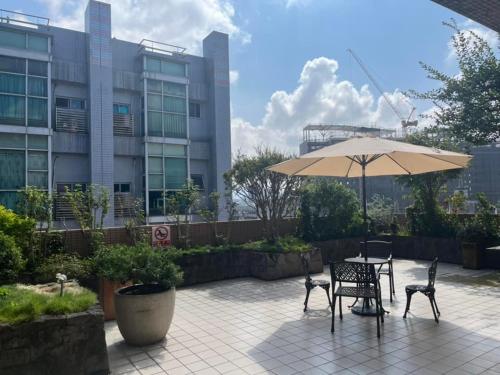 a patio with an umbrella and a table and chairs at XINSHE Hotel - Linsen in Taipei
