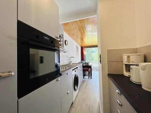 Il comprend une cuisine équipée d'un lave-linge et d'un sèche-linge. dans l'établissement Studio Cabine Rénové avec Balcon et Parking Près des Pistes – La Salle-les-Alpes - FR-1-330F-220, à La Salle Les Alpes