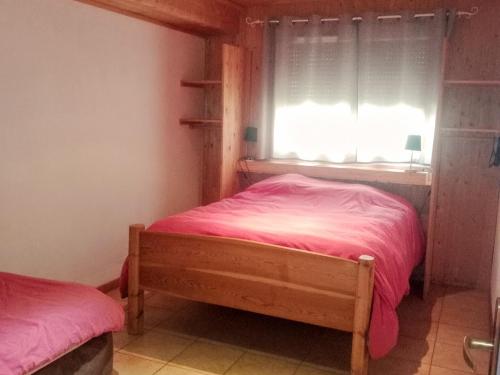 - une chambre avec un lit avec des draps roses et une fenêtre dans l'établissement Chalet 6 pièces avec cheminée, parking privé, proche Monêtier-les-Bains - FR-1-762-30, au Monêtier-les-Bains