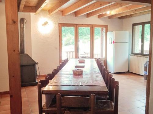 une salle à manger avec une grande table et un réfrigérateur dans l'établissement Chalet spacieux 6 pièces avec cheminée, barbecue, près des pistes, parking privé - FR-1-762-43, au Monêtier-les-Bains