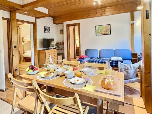 une salle à manger avec une table et un canapé dans l'établissement Charmant T3 avec 2 salles de bain, proche pistes et commodités à Val-d'Isère - FR-1-411-898, à Val dʼIsère
