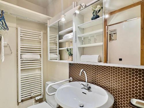 une salle de bain avec un lavabo blanc et des toilettes dans l'établissement Charmant T3 avec 2 salles de bain, proche pistes et commodités à Val-d'Isère - FR-1-411-898, à Val dʼIsère