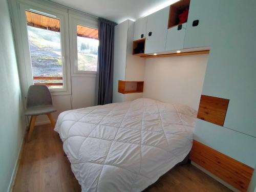 une chambre avec un lit et une chaise dedans dans l'établissement Avoriaz, appartement 4 pers, balcon, wifi, proche du centre. - FR-1-633-79, à Morzine