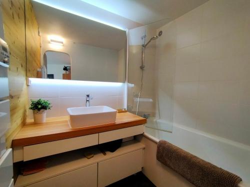 une salle de bain avec un lavabo, un miroir et une baignoire dans l'établissement Avoriaz, appartement 4 pers, balcon, wifi, proche du centre. - FR-1-633-79, à Morzine
