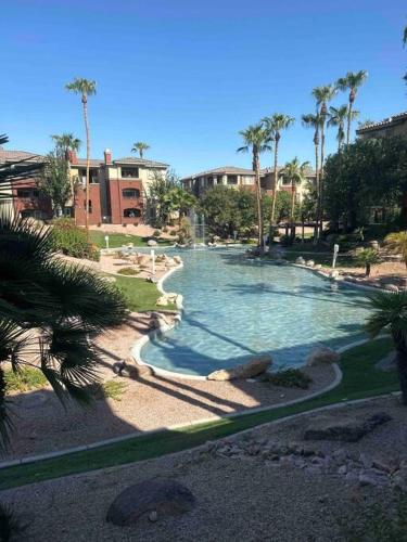 a large swimming pool in a resort with palm trees at Cozy Condo in Gated Community with Pool by PHX Airport, Tempe, and Old Town in Phoenix