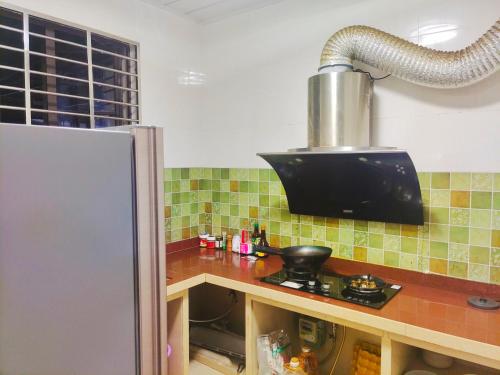 eine Küche mit einer Arbeitsplatte und einem Kühlschrank in der Unterkunft 闲肆民宿 in Sanya