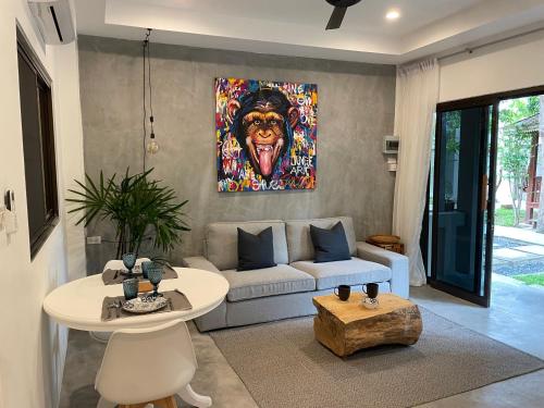 una sala de estar con una pintura de mono en la pared en PATAMAAN COTTAGES en Nathon Bay