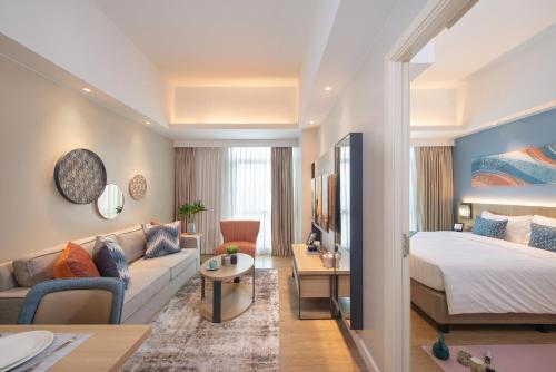 pokój hotelowy z łóżkiem i kanapą w obiekcie Citadines Roces Quezon City w mieście Manila