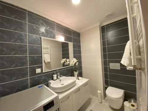 bagno con lavandino, servizi igienici e specchio di Super Large, Lux, Romantic and Modern Duplex Penthouse, 5 min to Forum Istanbul, Bus, Metro, Tram, Major Shopping Centers, & Many More Rent follows governmental instructions a Istanbul