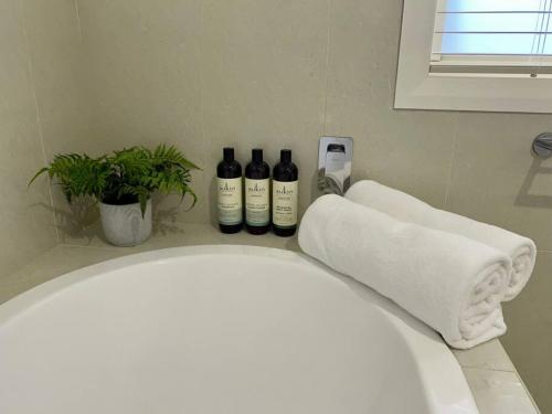 three bottles of wine sitting on a counter in a bathroom at Katoomba Cottage in Katoomba