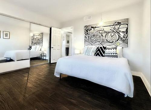a bedroom with a white bed and a painting on the wall at Global Cup Dallas Urban Comfort and Arboretum Tickets in Dallas