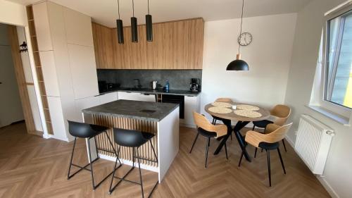 een keuken met een tafel en stoelen in een kamer bij ApartamentLesznoPL Family Friendly in Leszno