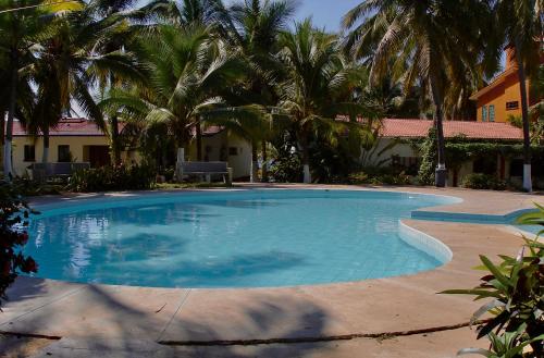 una gran piscina con palmeras en el fondo en ESTUDIO 21, en Barra de Navidad