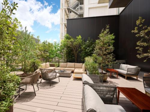 a patio with furniture and trees and a building at The Royal Park Canvas Fukuoka Nakasu in Fukuoka