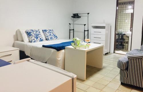ein Wohnzimmer mit einem Bett und einem Tisch in der Unterkunft Pousada Familiar e Domiciliar - Perto do Aeroporto de Salvador in Lauro de Freitas