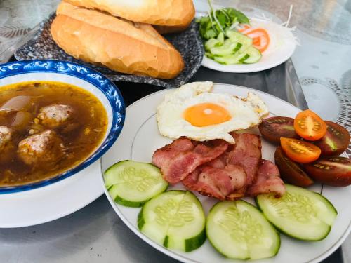 een tafel vol borden met eten, waaronder eieren, vlees en groenten bij Villa - Hotel Nam Khang 2 Dalat in Da Lat