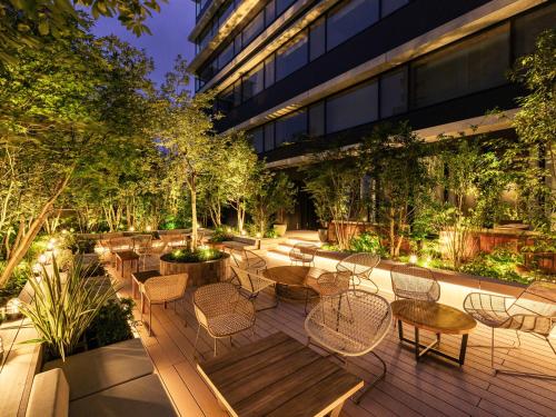 a courtyard with tables and chairs and a building at The Royal Park Canvas Fukuoka Nakasu in Fukuoka