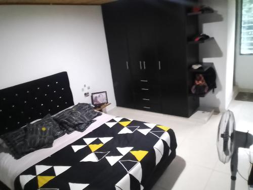 een slaapkamer met een bed met een zwart en geel dekbed bij HyH Estadía Gourmet in Ibagué