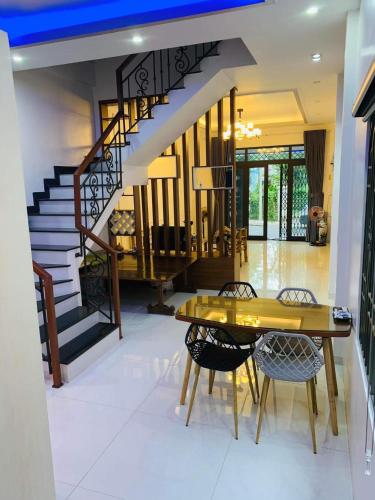 a dining room with a staircase and a table and chairs at Êm Home 3 Phòng Ngủ in Hue