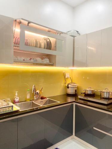 a kitchen with white cabinets and a sink at Êm Home 3 Phòng Ngủ in Hue