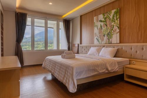 a bedroom with a large bed with a large window at Lavender - Taman Tanda in Bedugul