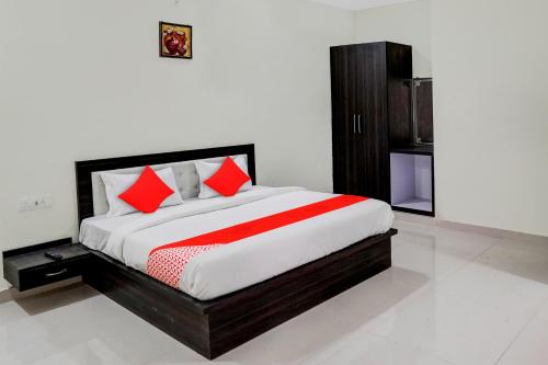 a bedroom with a large bed with red pillows at Super OYO Flagship A R V Palace in Lucknow